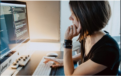 Person working at a desk with code on screen